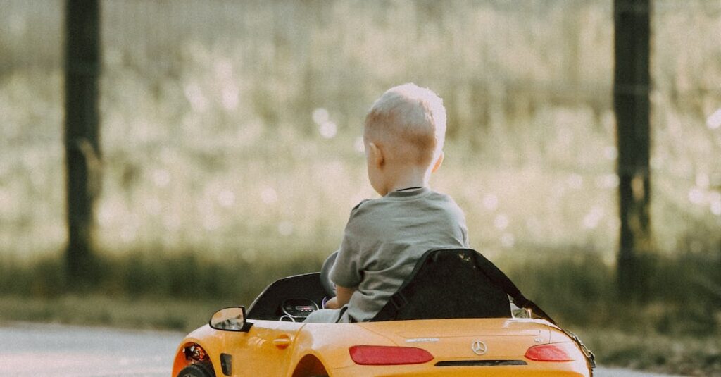 Young child enjoys riding a mini toy car in an outdoor park on a sunny day.