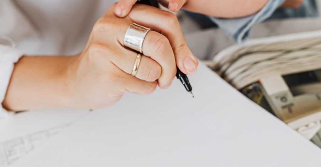 Close-up of a parent and child writing on paper together indoors, showcasing bonding and creativity.