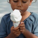 A young girl savoring an ice cream cone on a sunny day.