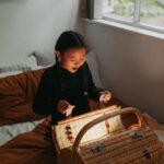 A child joyfully discovers glowing magic inside a basket in a cozy bedroom setting.