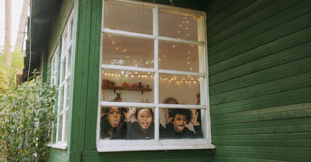 Three joyful children making faces at the window of a cozy cabin, surrounded by autumn scenery.