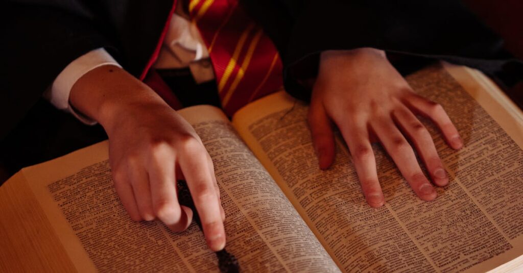 A child dressed as a wizard reading a spellbook and holding a wand.
