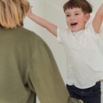 Joyful mother and son playing indoors, embracing happiness and togetherness.