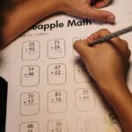 A child focuses on solving a math worksheet at a home study desk, fostering learning and concentration.